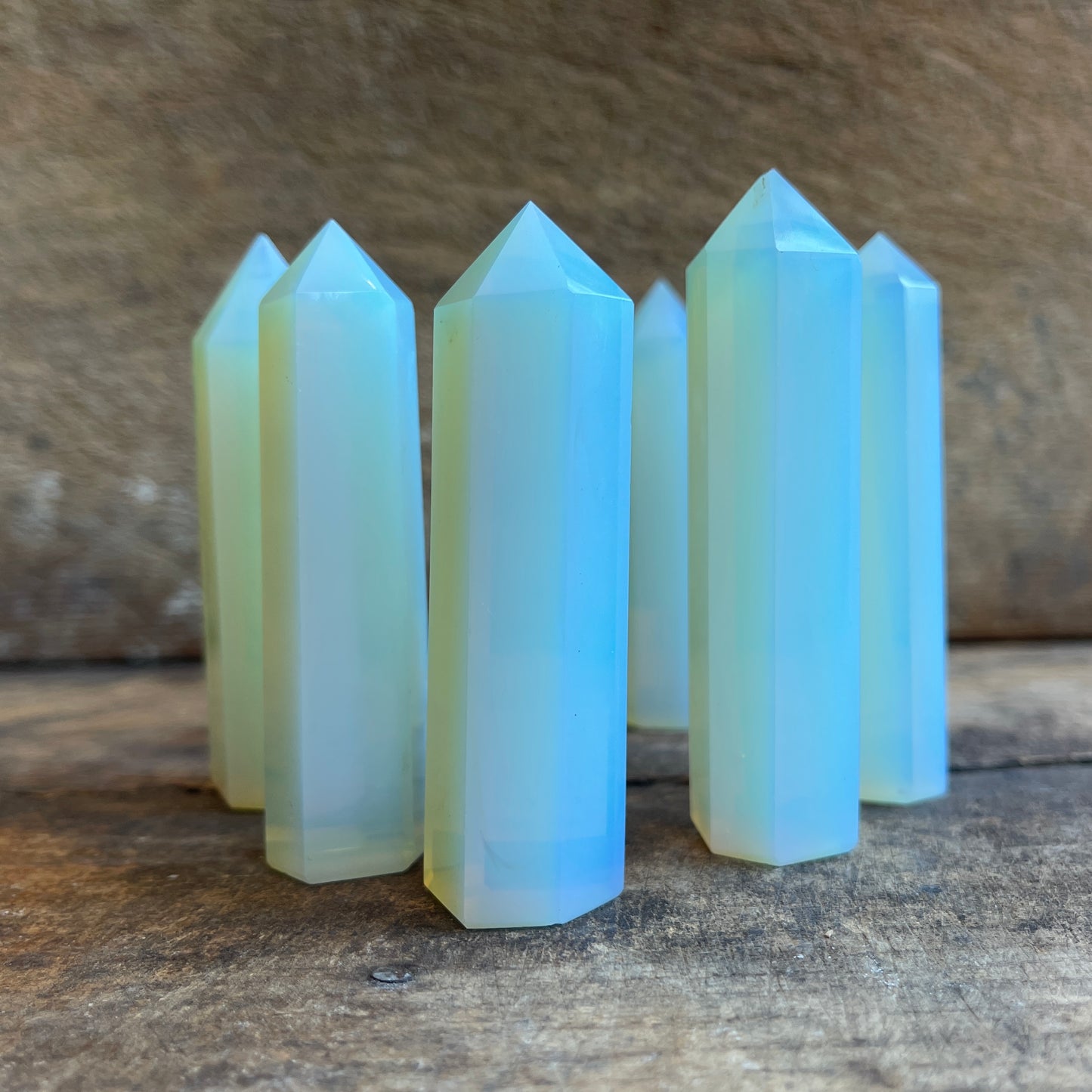 Multiple opalite crystal points on a wooden surface