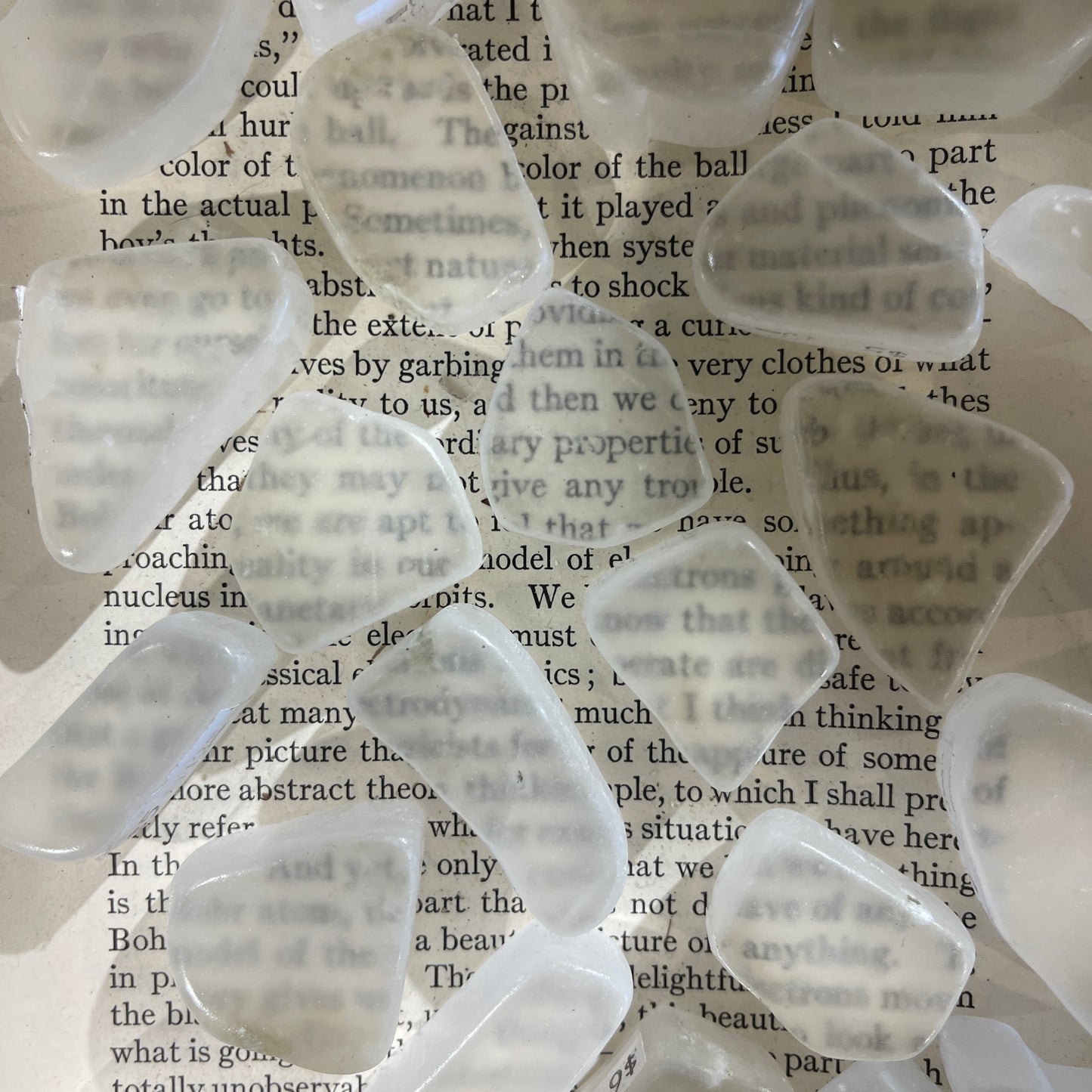 Multiple pieces of ulexite over text from a book