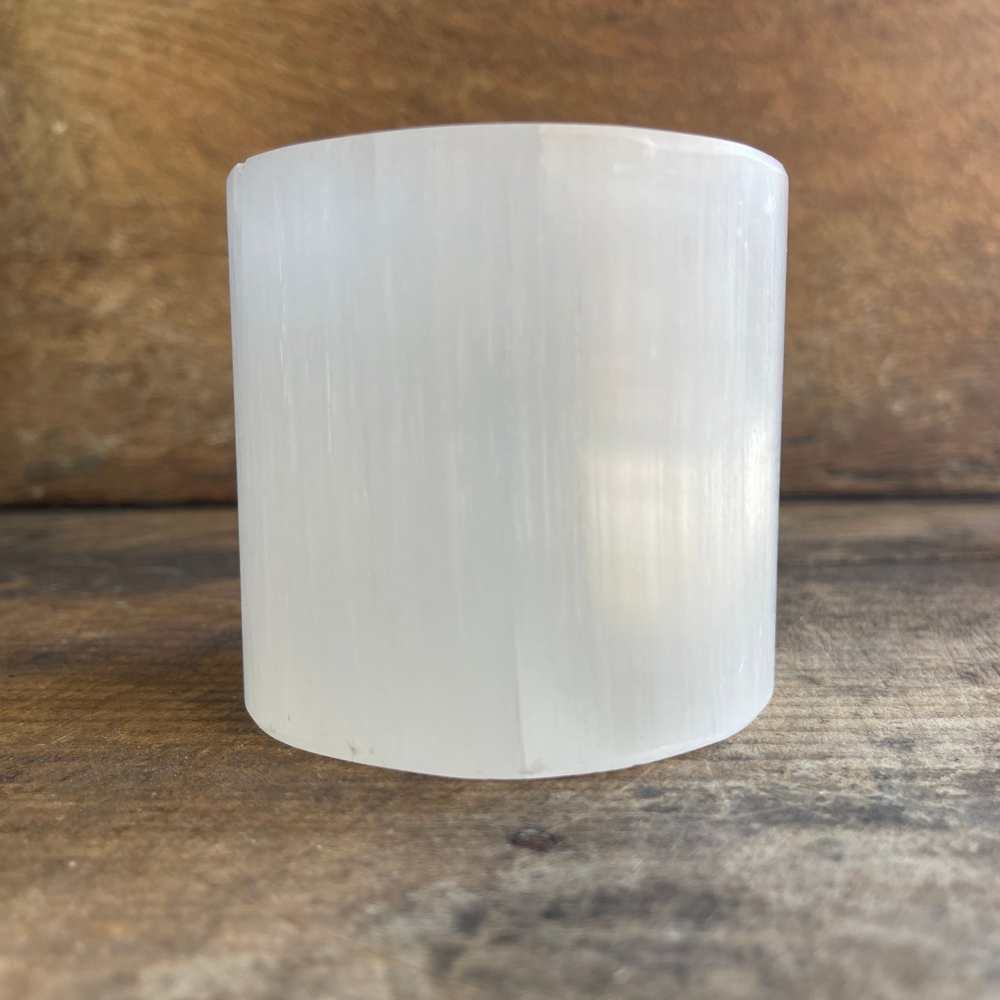 Cylindrical white crystal on a wooden surface