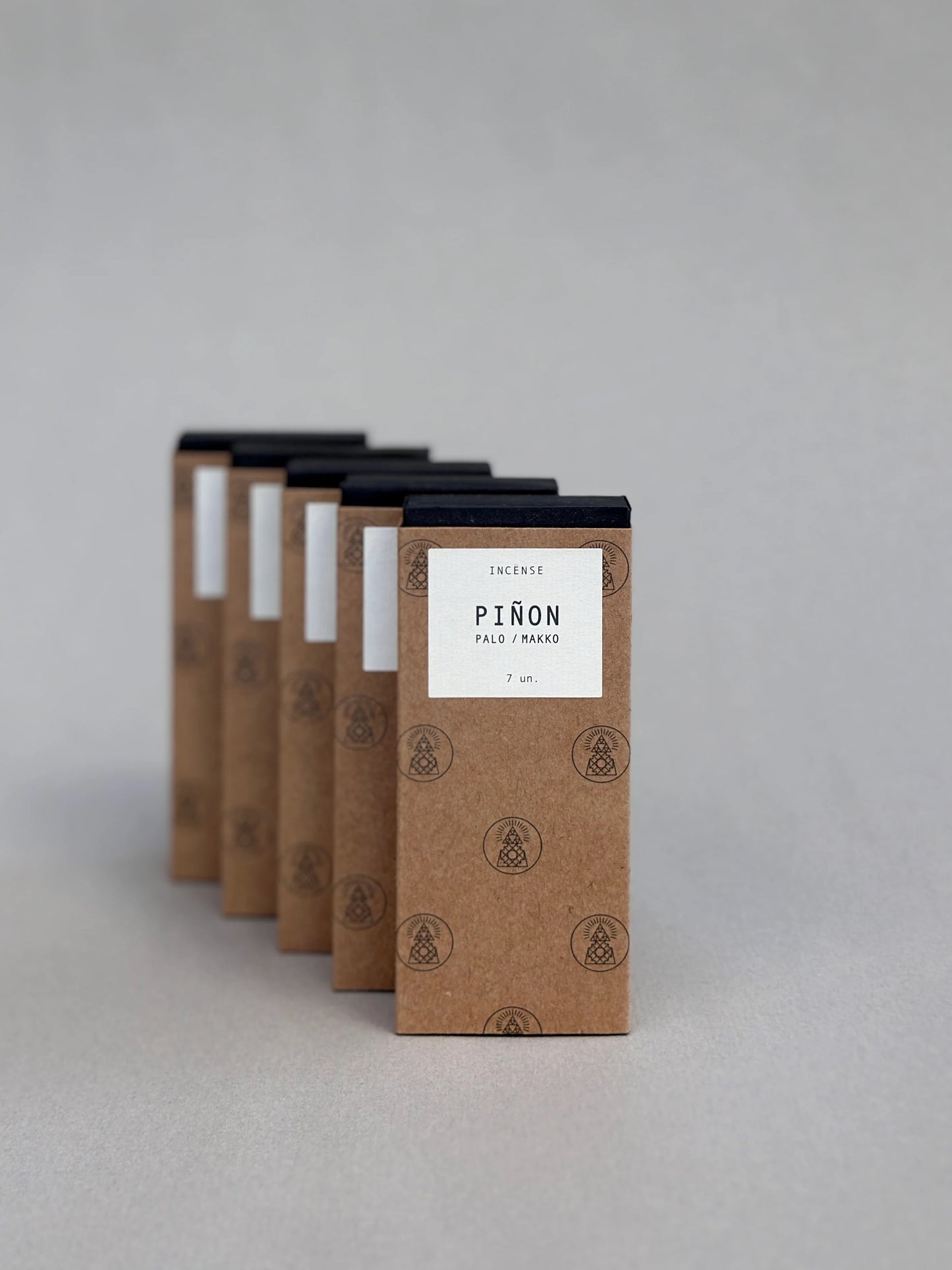 Row of brown incense boxes with white labels on a gray background