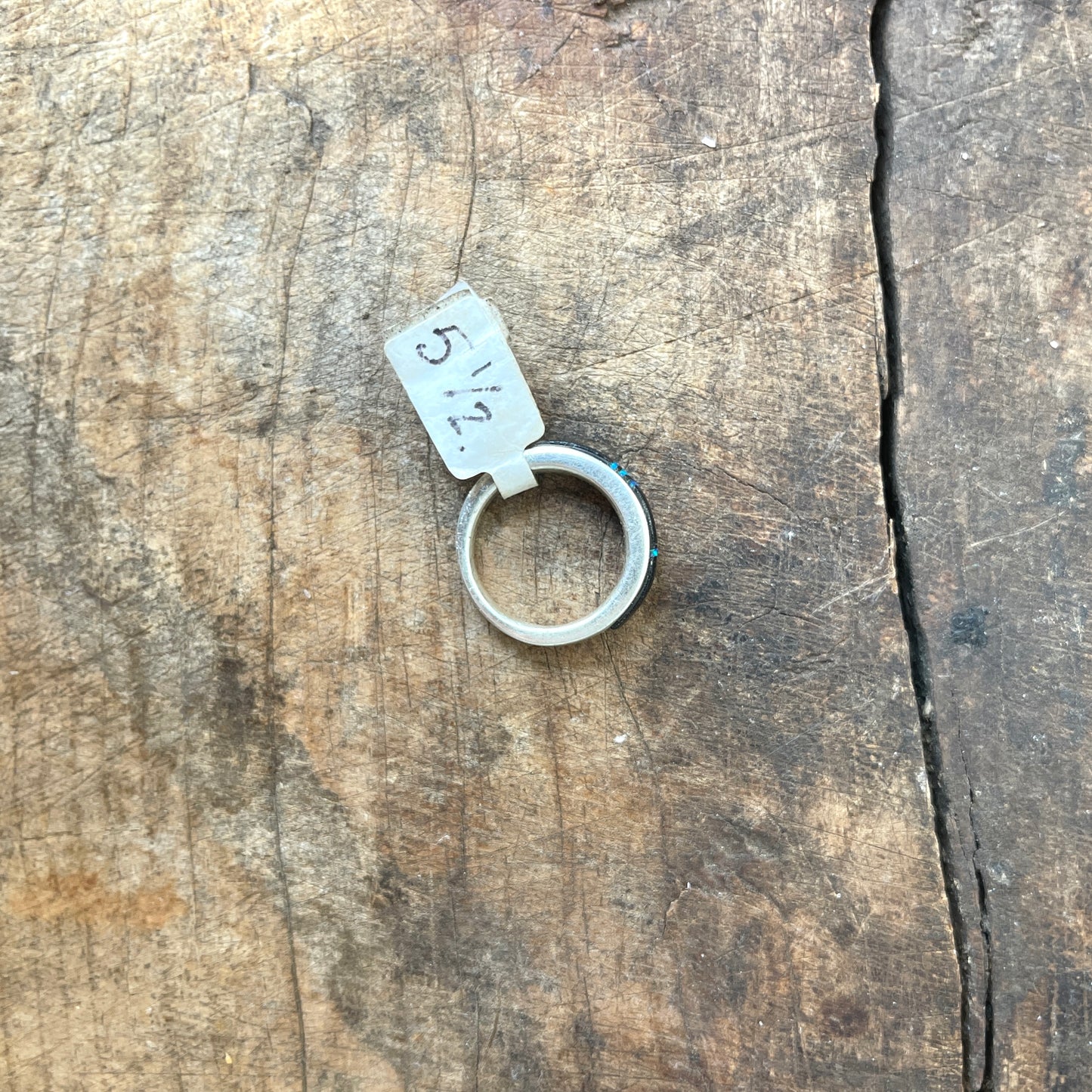 Silver ring with size marker on a wooden surface