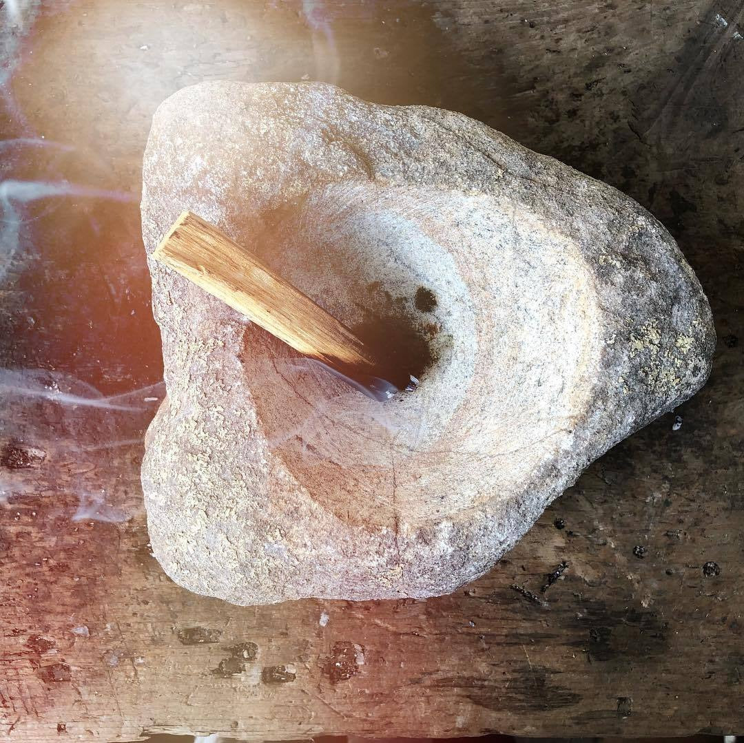 Palo santo burning in stone dish
