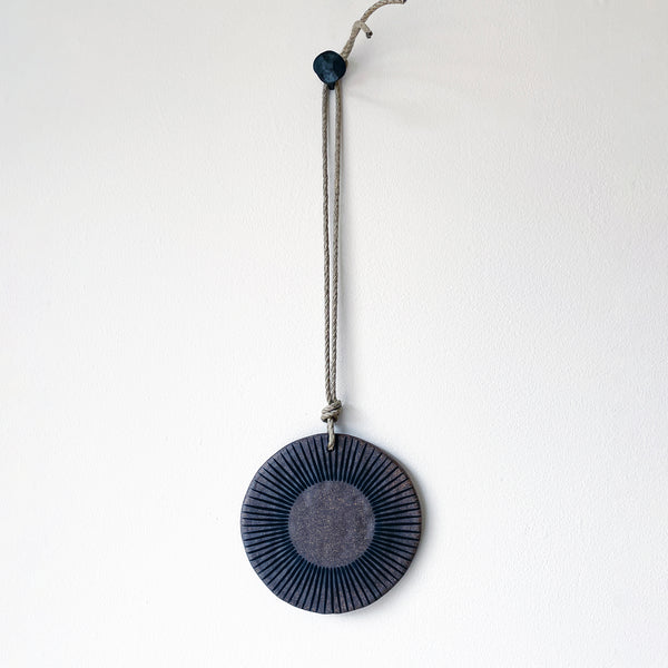 Round ceramic wall hanger with brown and black design