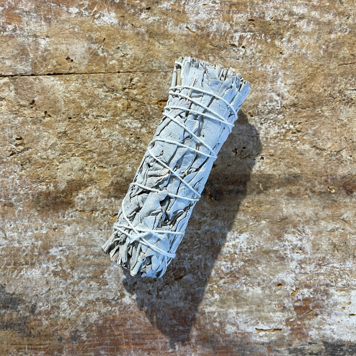 White sage bundle on a textured wooden surface