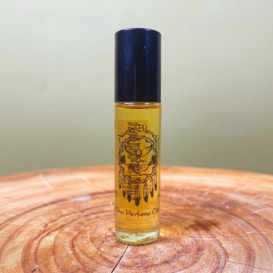 Perfume oil bottle with blue cap and yellow label on a wooden surface