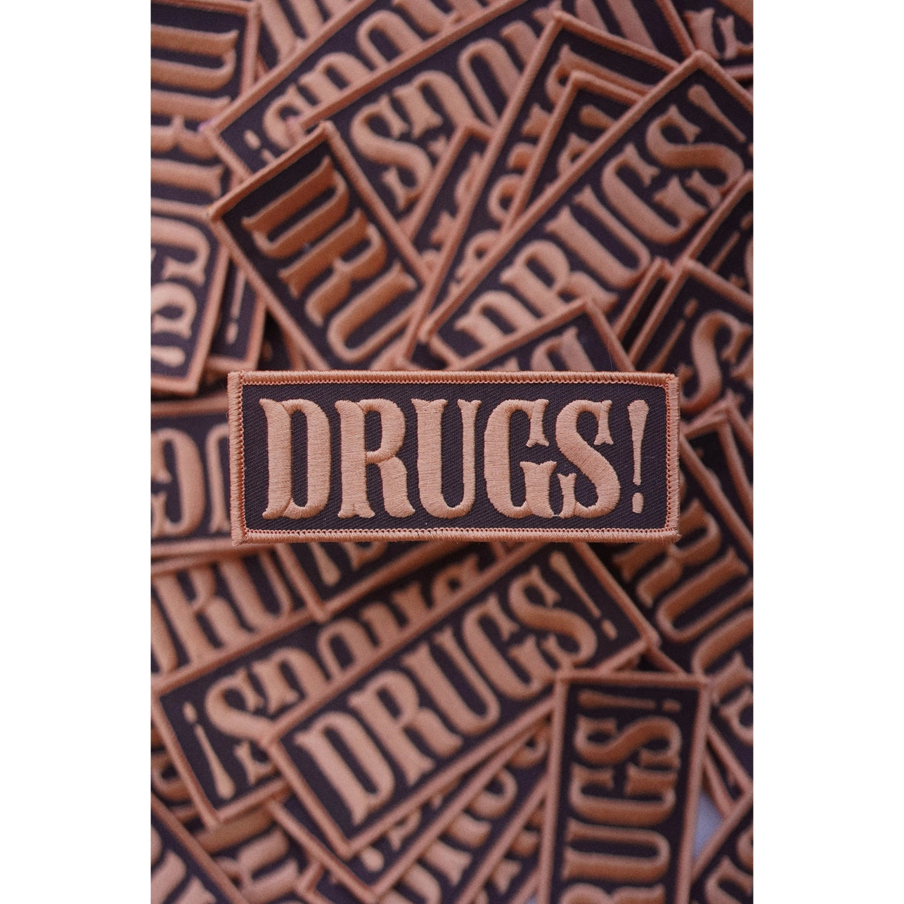 Patch with 'DRUGS!' text on a brown background