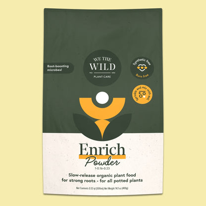 A package of Enrich Powder plant food by We The Wild, featuring a dark green and white design with a stylized yellow plant logo, set against a pale yellow background.