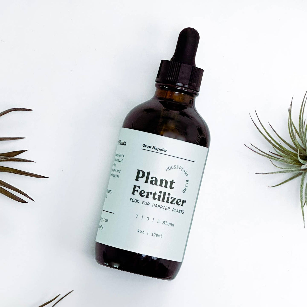 Bottle of plant fertilizer with a dropper on a white background