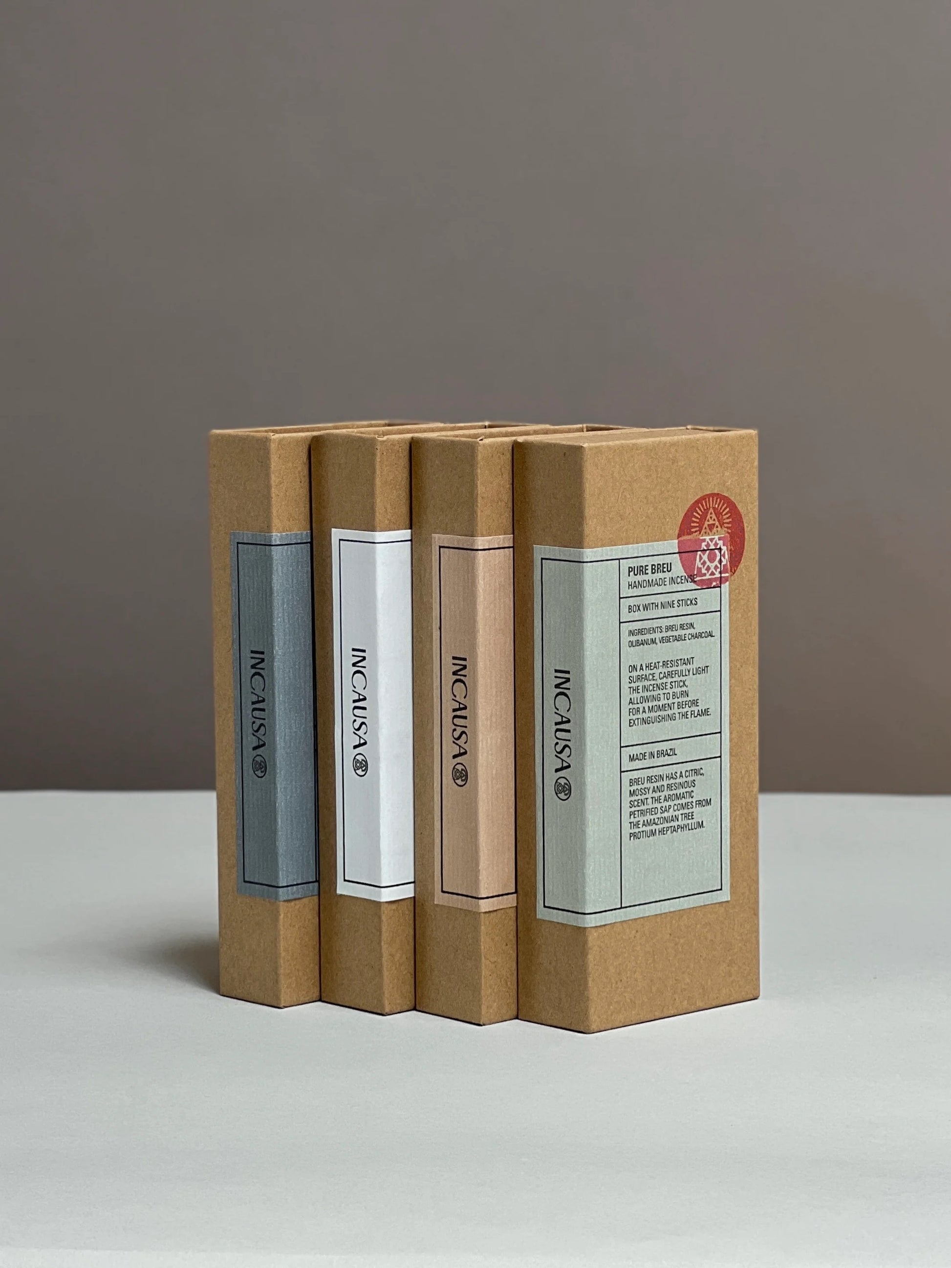 Grouping of 4 assorted rectangular incense boxes on a white surface