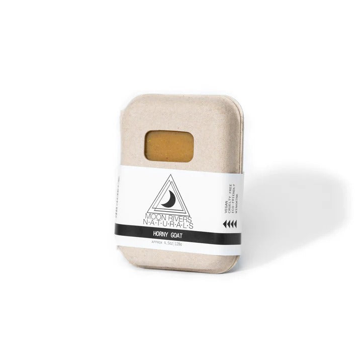 Bar of soap in a beige container with a white label on a white background