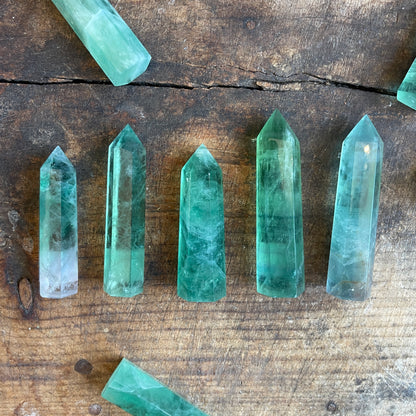 Green crystal points on a wooden surface