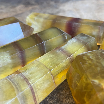 Polished stone slabs with yellow and brown bands on a wooden surface