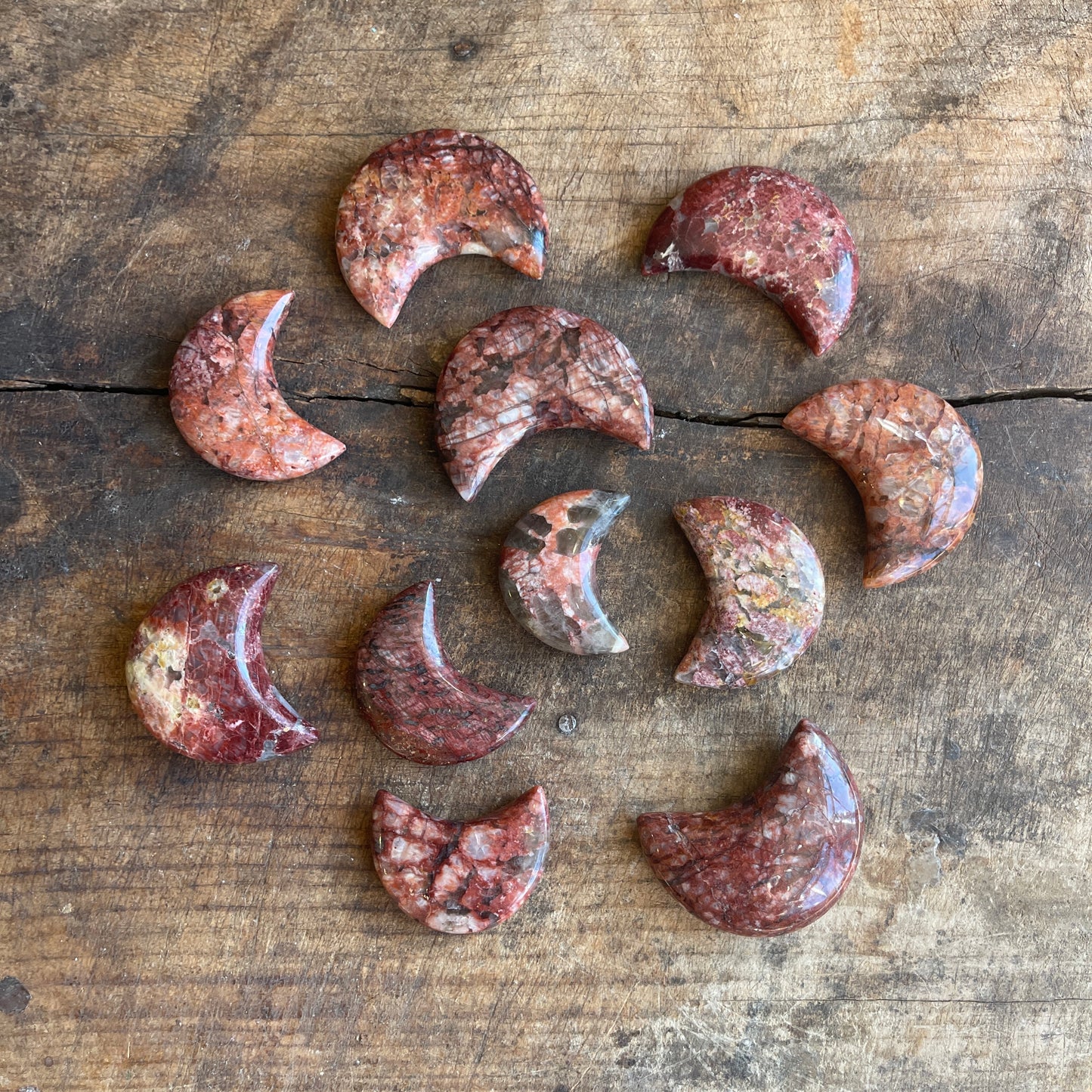 Collection of jasper crescent moons on a wooden surface