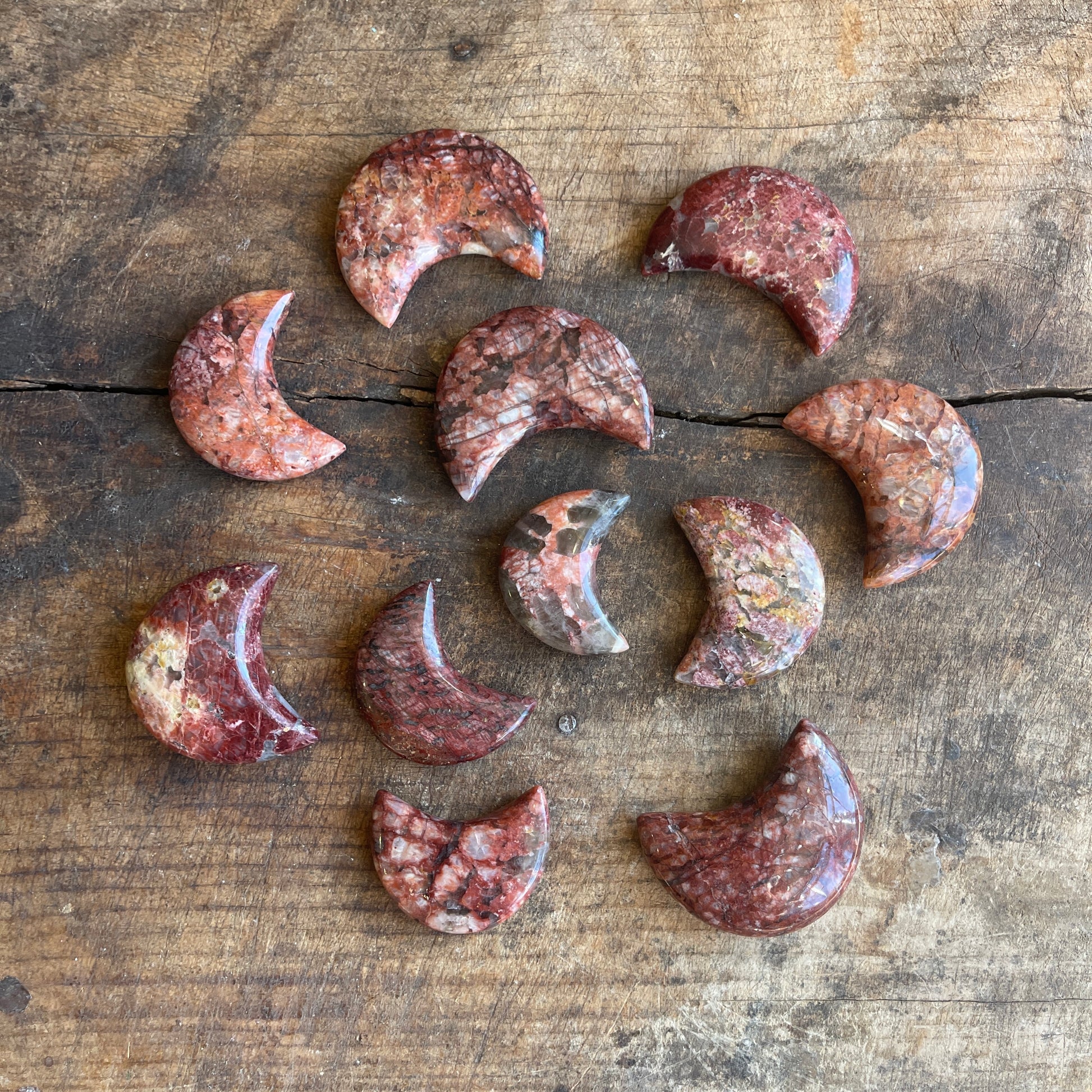 Collection of jasper crescent moons on a wooden surface