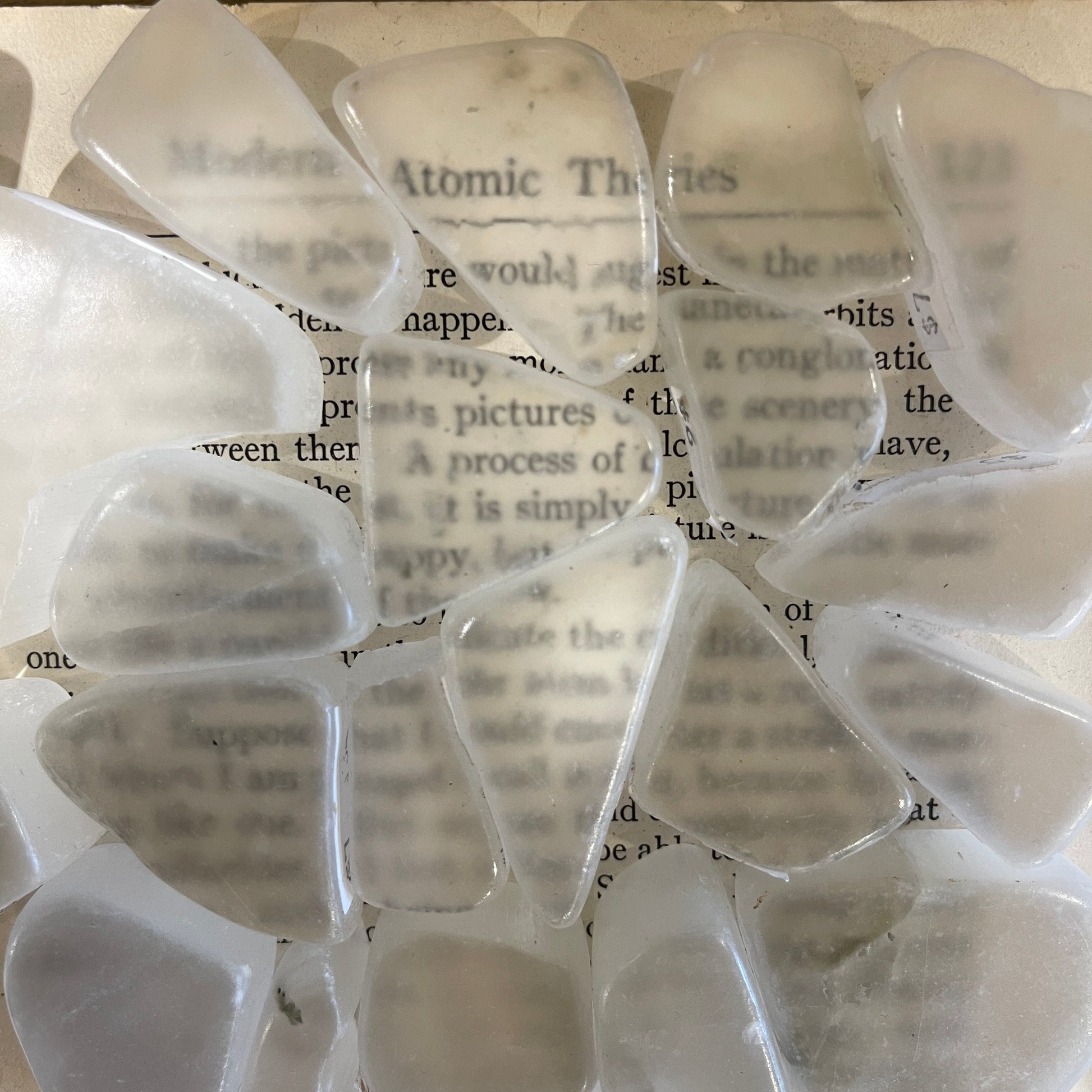 Multiple pieces of ulexite over text from a book