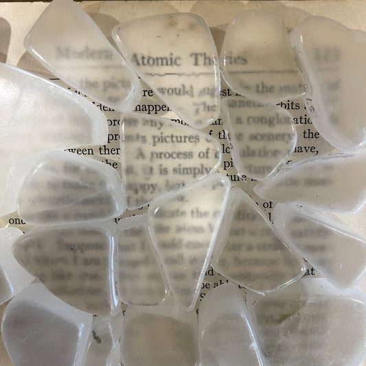 Multiple pieces of ulexite over text from a book