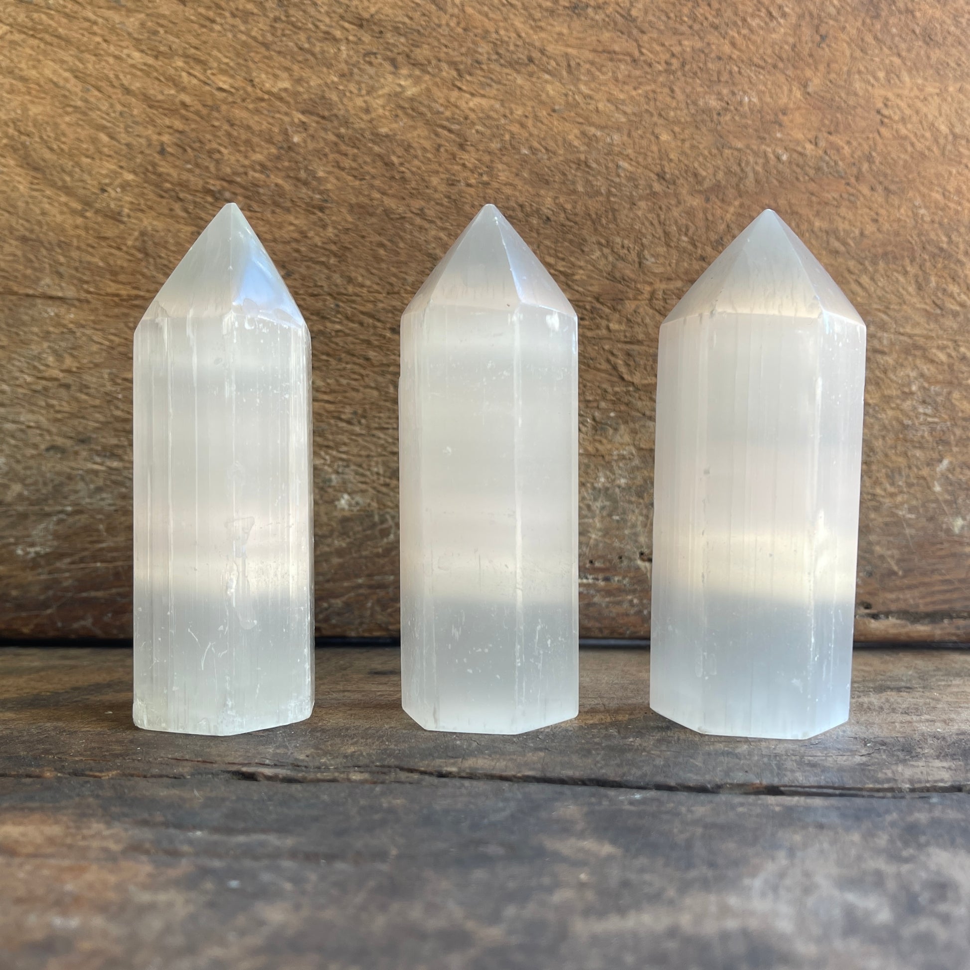 Three crystal towers on a wooden surface with a wooden background