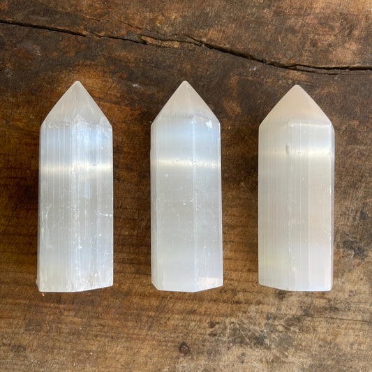 Three crystal points on a wooden surface