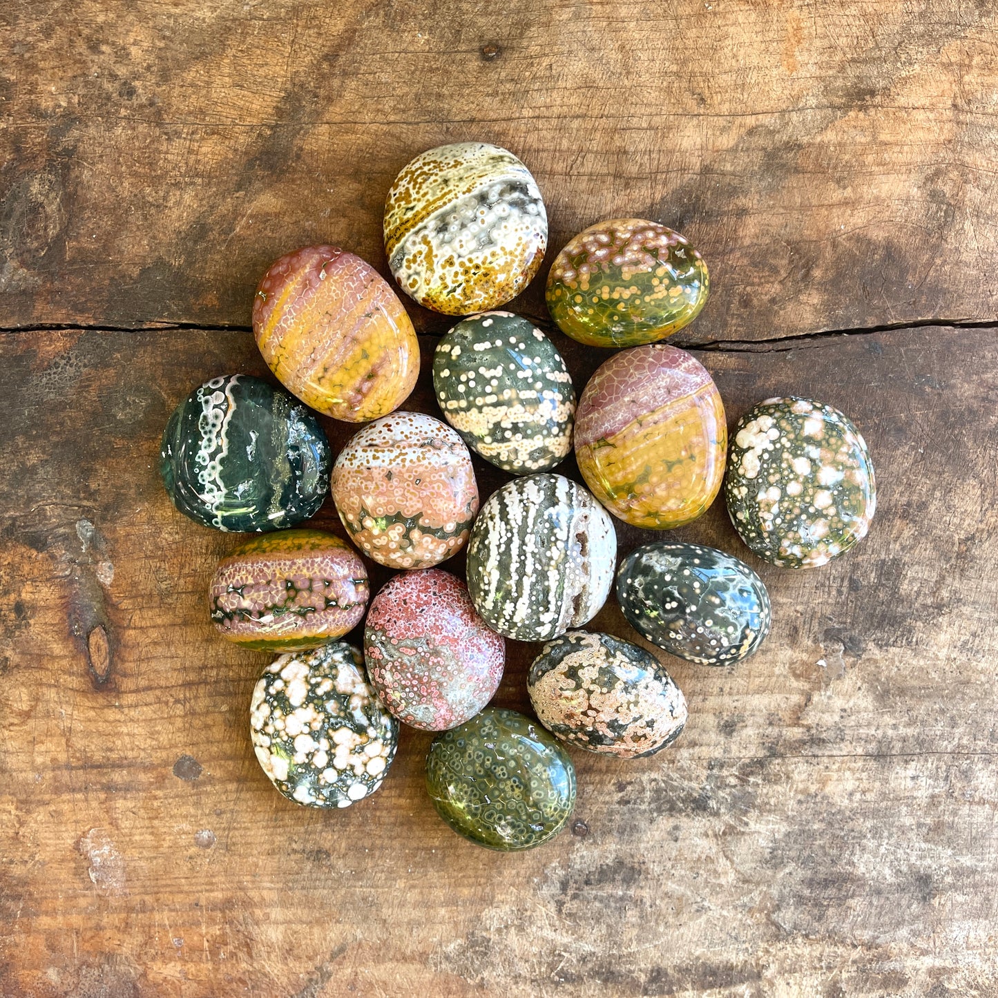 Collection of multicolored marbled stones on a wooden surface