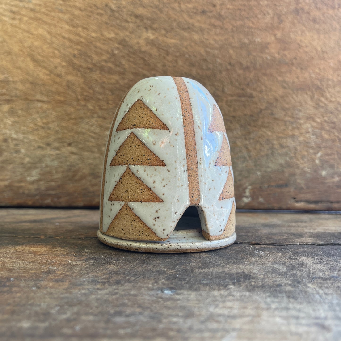Ceramic incense hut with geometric design on a wooden surface