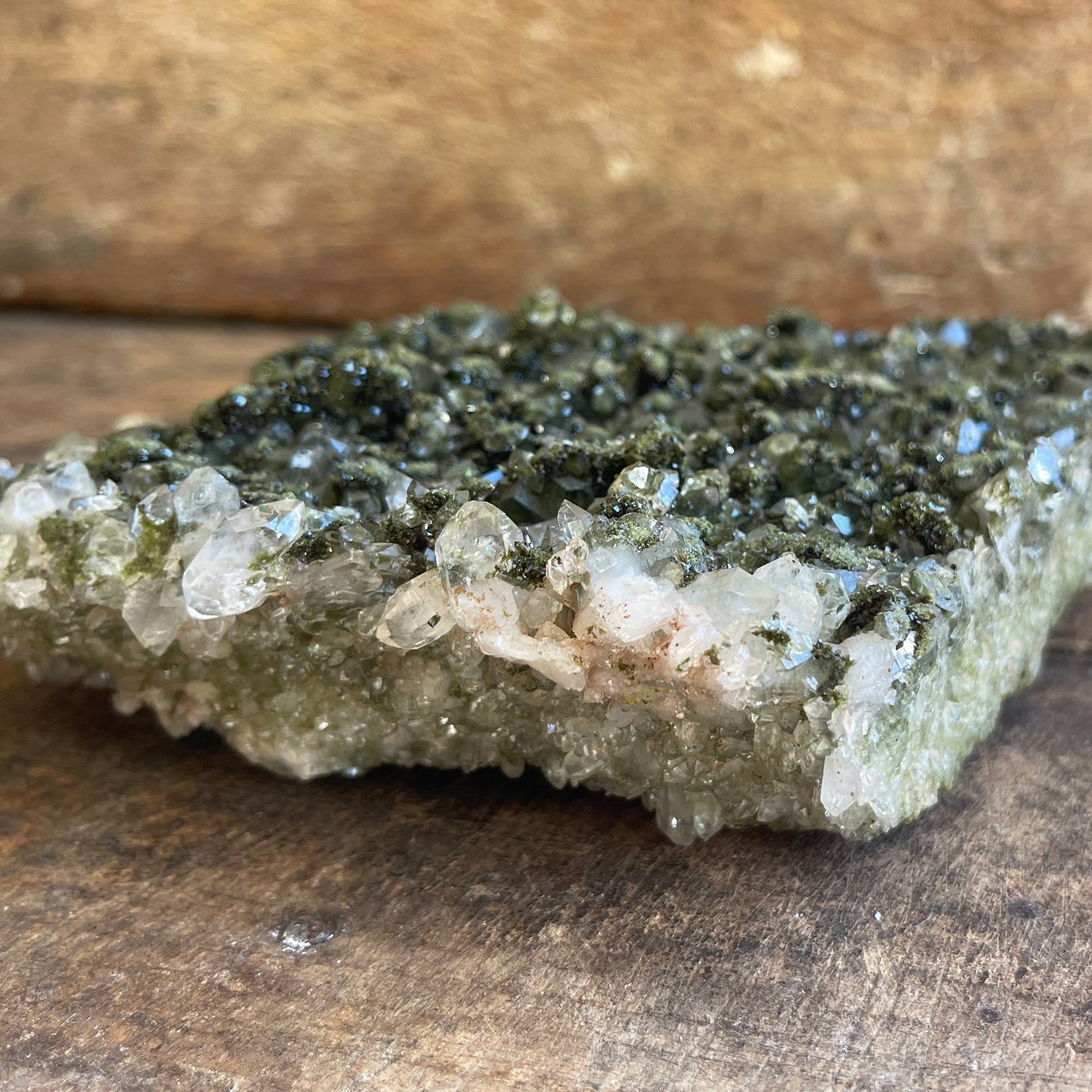 Mineral sample with crystals on a wooden surface