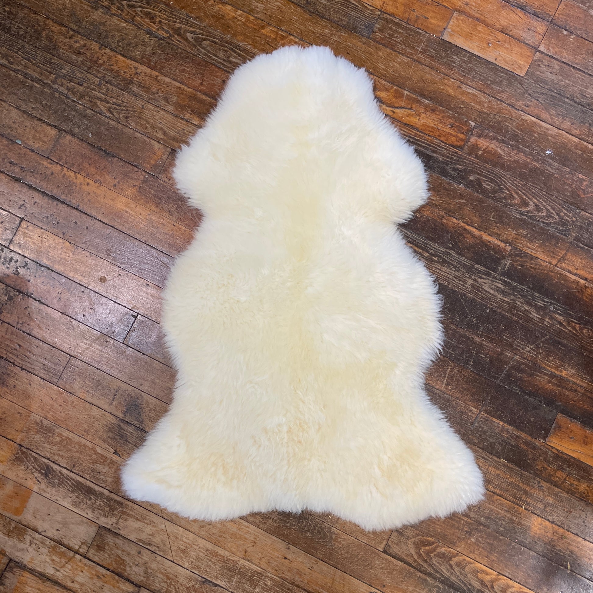 White sheepskin rug on a wooden floor