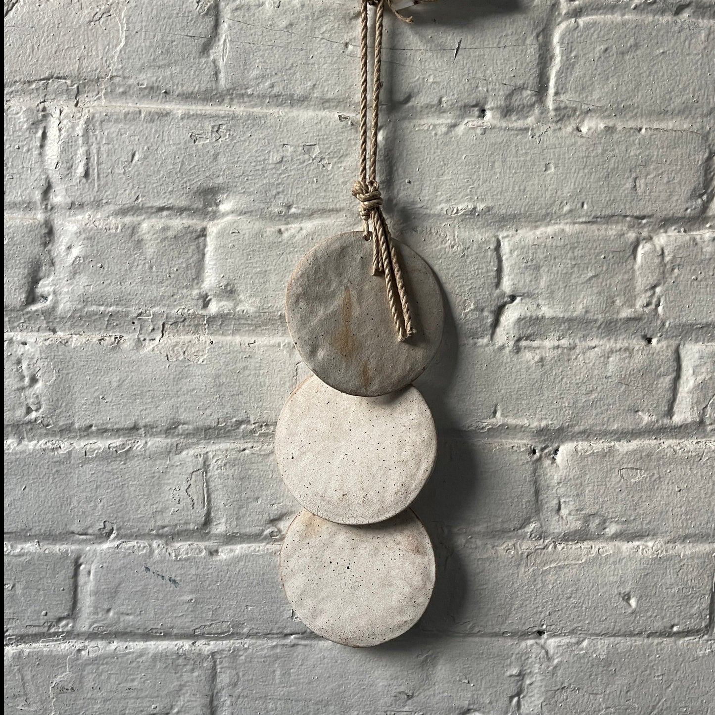 Wall hanger made from 3 ceramic discs, strung from rope