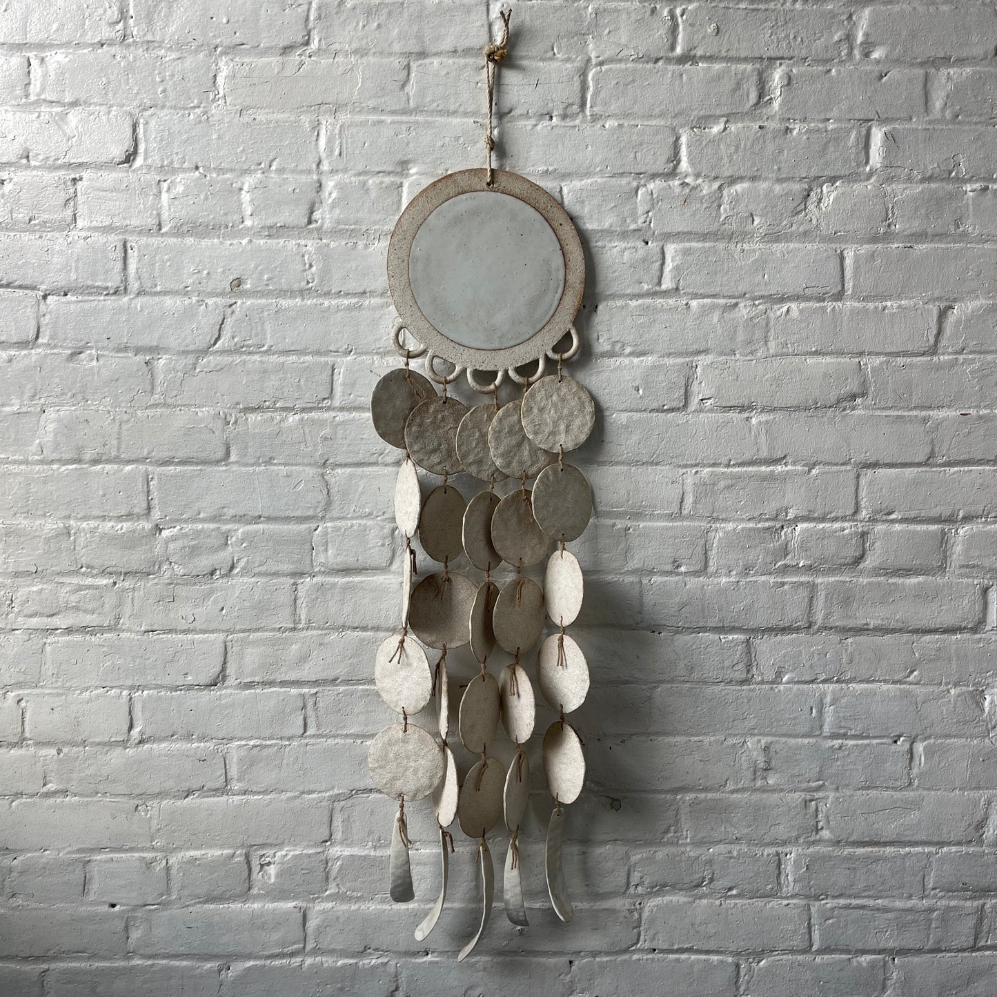 White ceramic dreamweaver against white brick wall