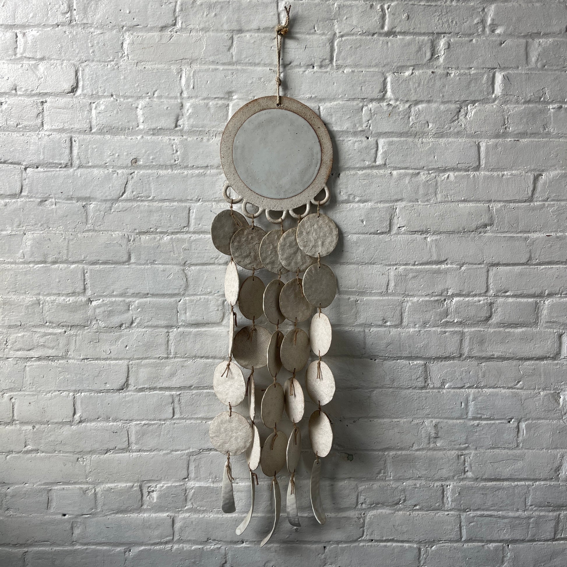 White ceramic dreamweaver against white brick wall