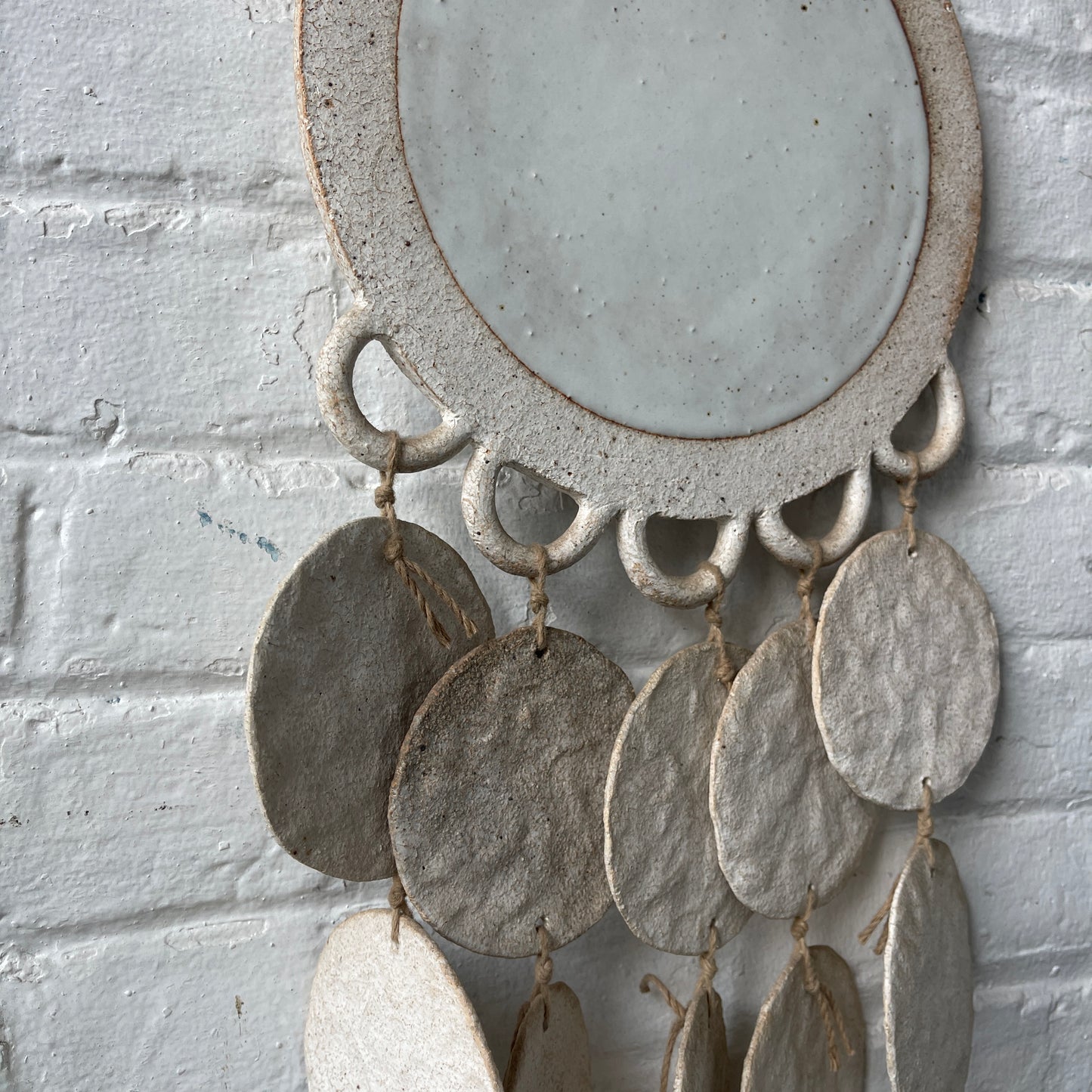 White ceramic dreamweaver against white brick wall