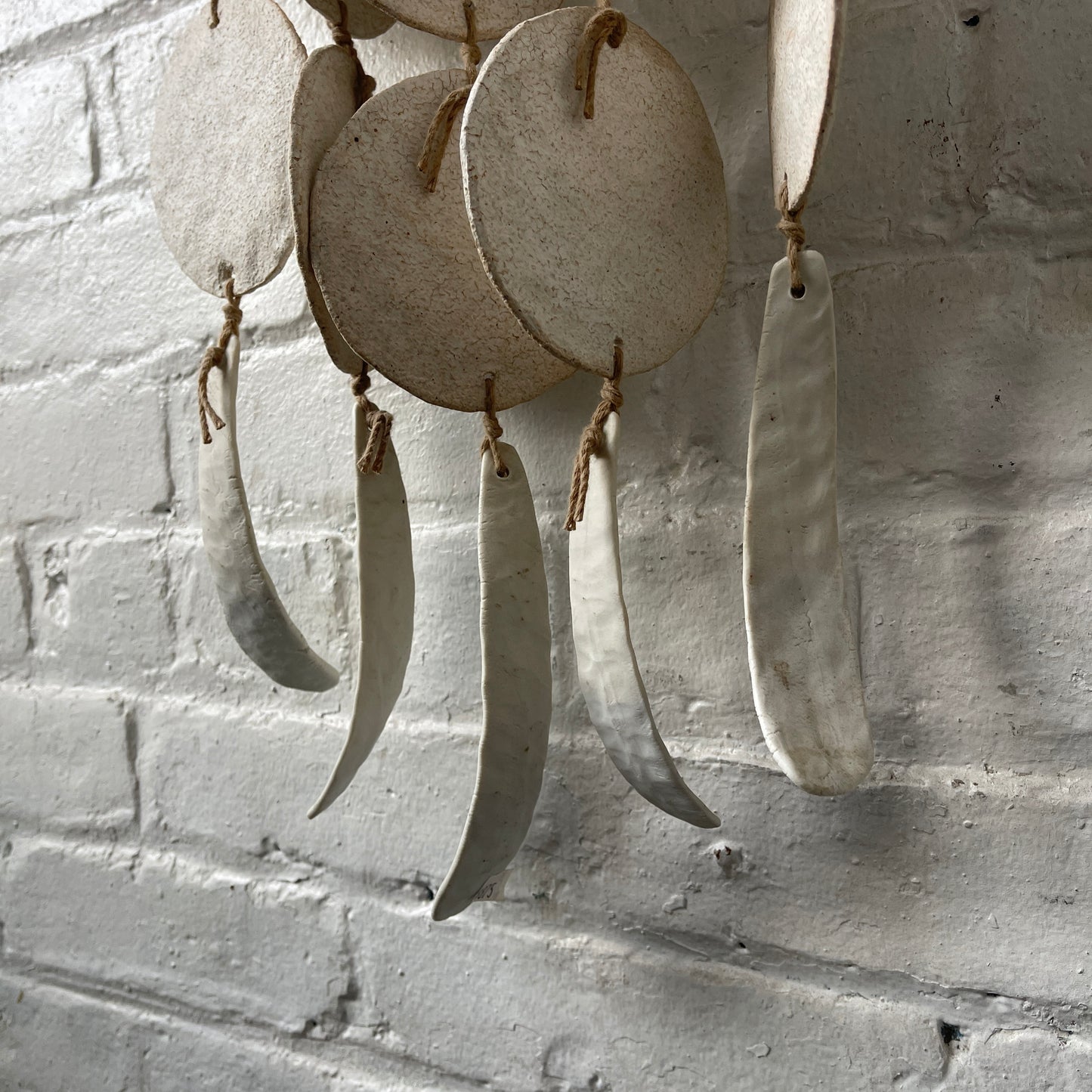 White ceramic dreamweaver against white brick wall