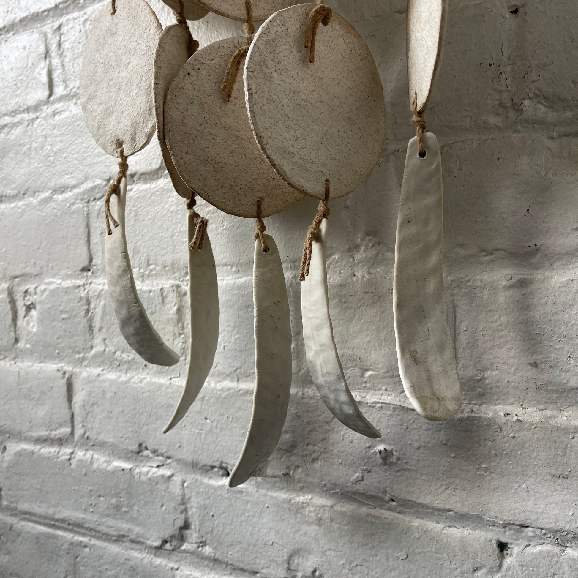 White ceramic dreamweaver against white brick wall