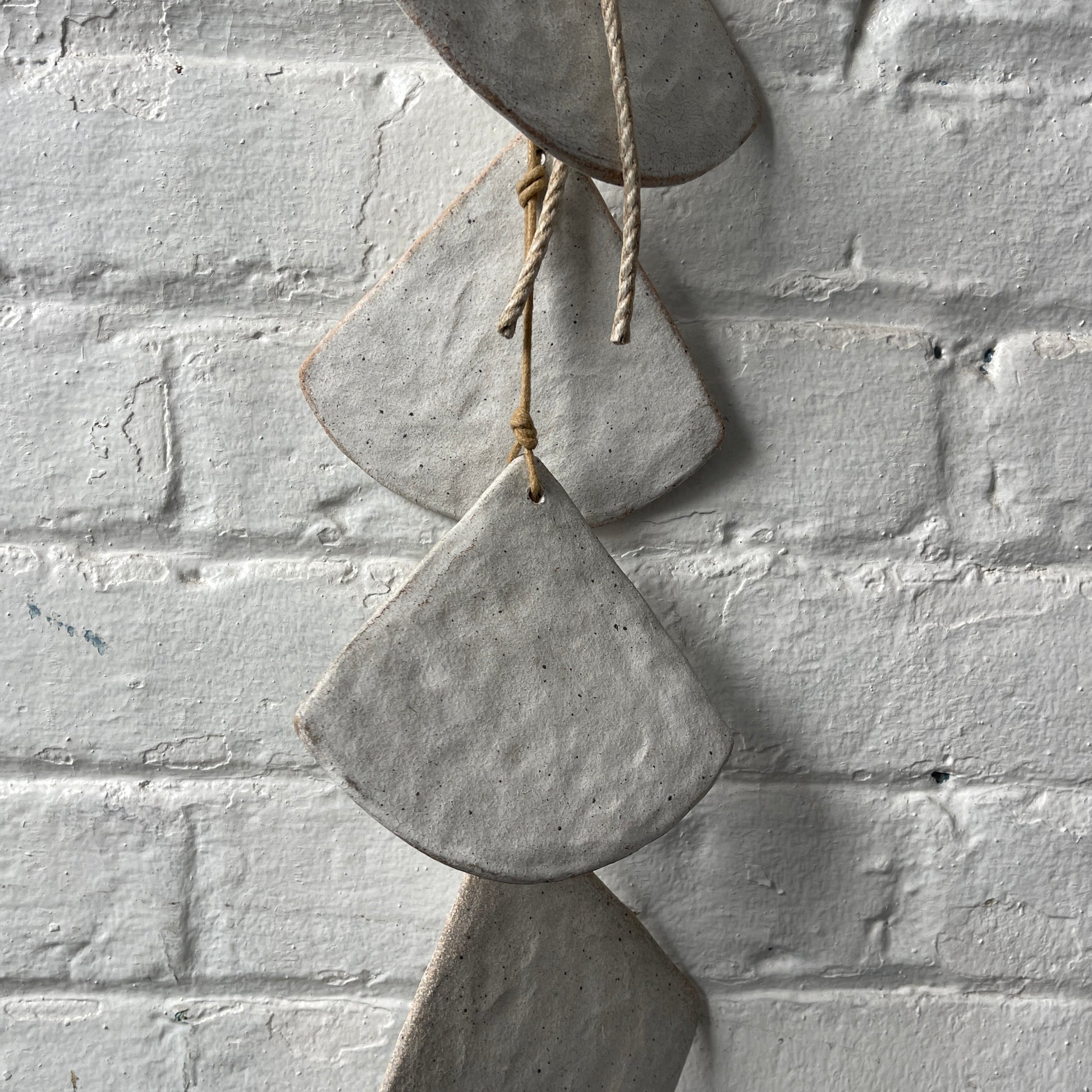 Layered White stoneware shells against a white brick wall