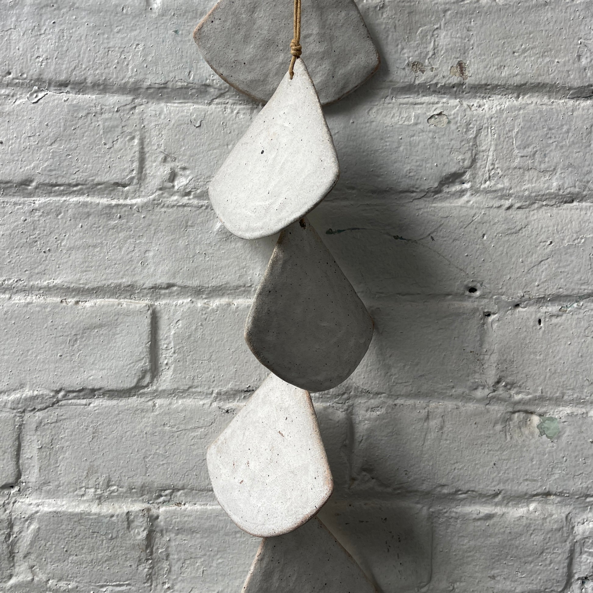 Layered White stoneware shells against a white brick wall