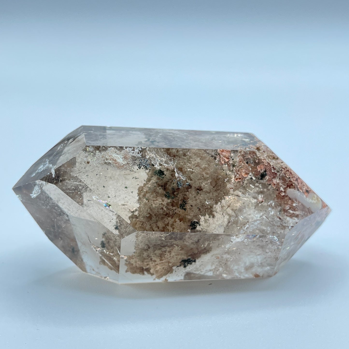 Hexagonal crystal with brown and clear patterns on a light blue background