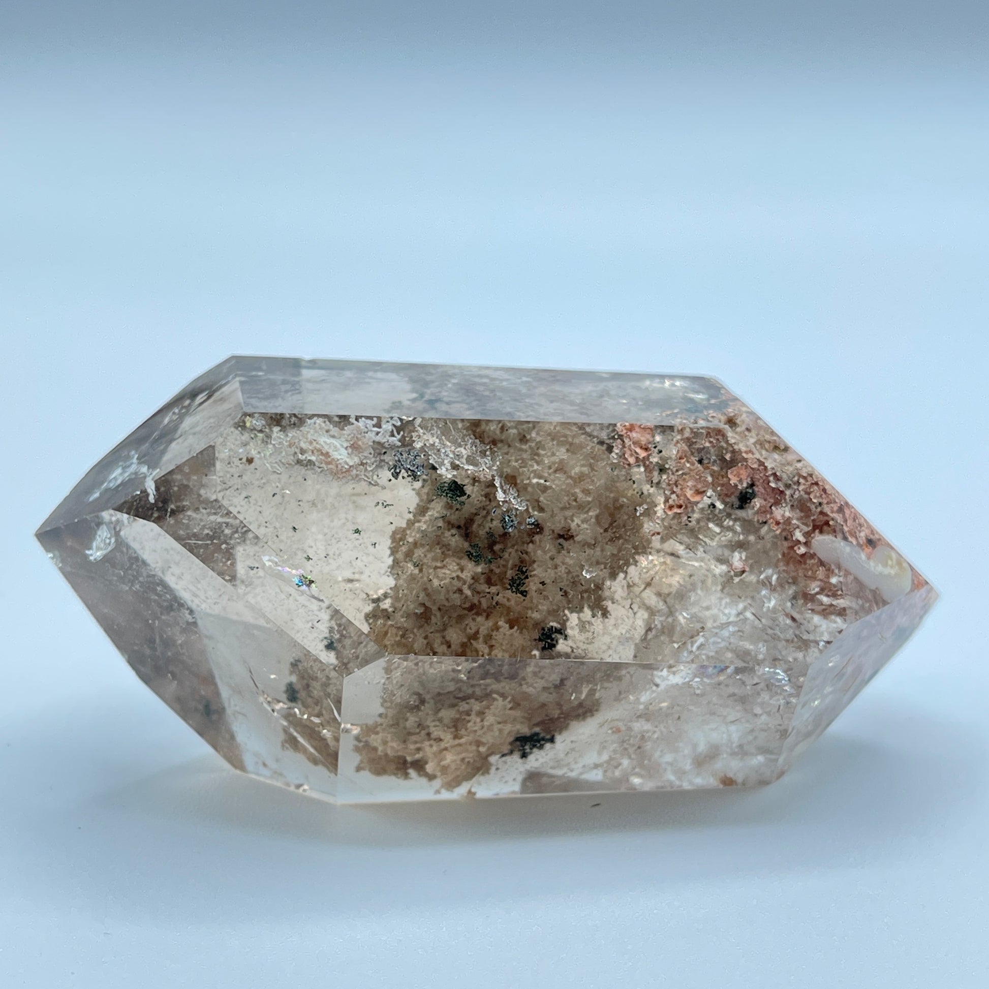 Hexagonal crystal with brown and clear patterns on a light blue background