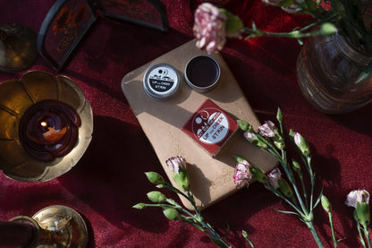 Wooden board with tea canisters and flowers on a red fabric background