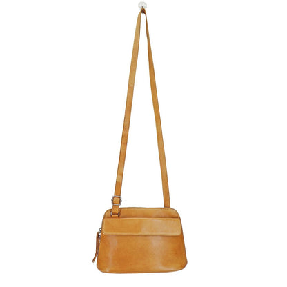 Tan leather crossbody bag with a strap on a white background