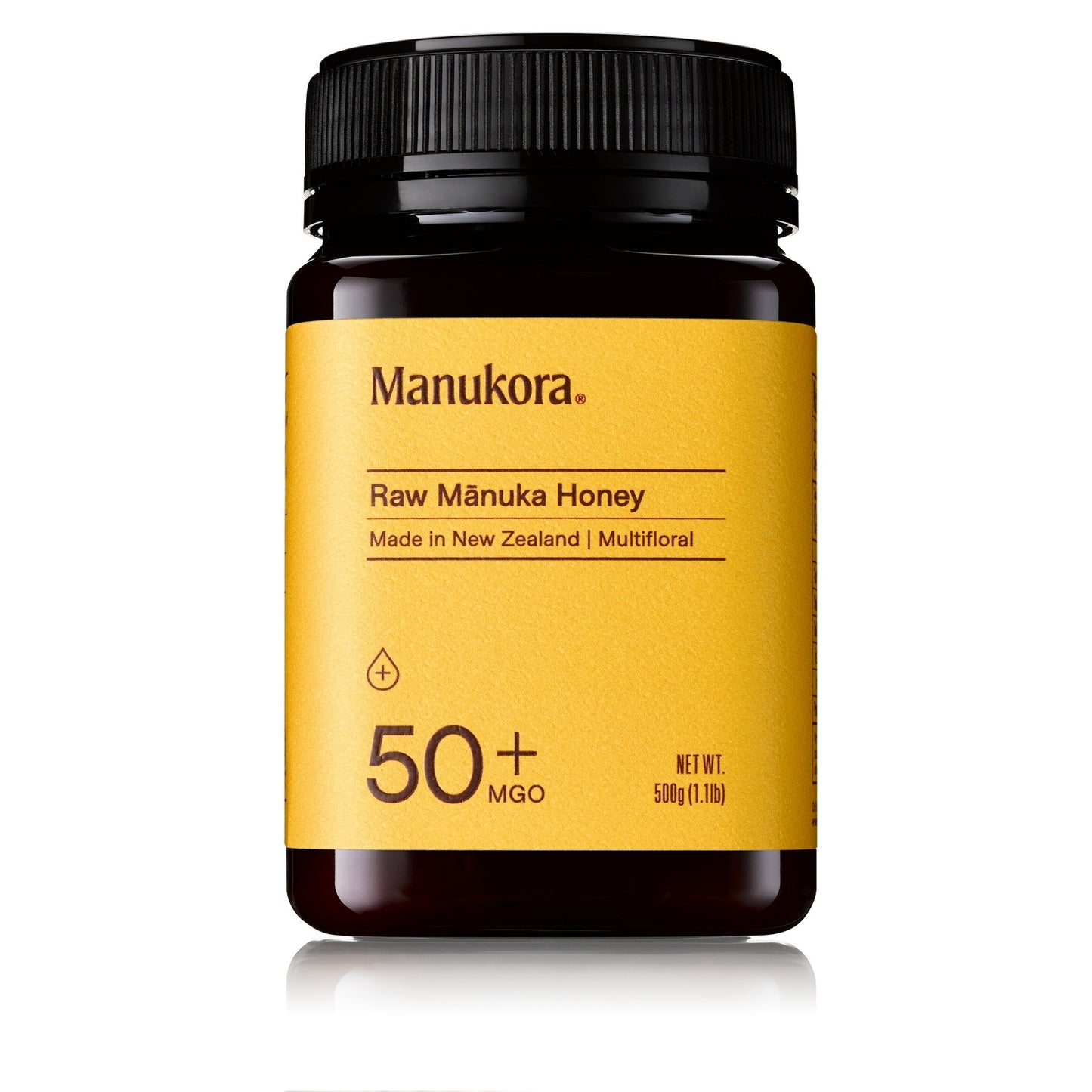 Manukora Raw Manuka Honey jar with yellow label and black lid on a white background