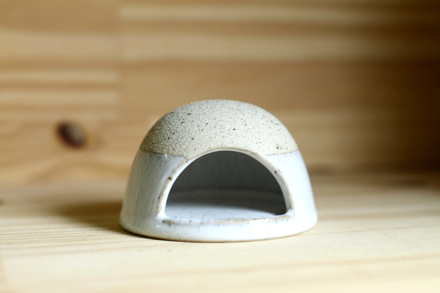 Ceramic dome-shaped match striker on a wooden surface