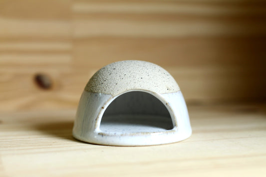Ceramic dome-shaped match striker on a wooden surface