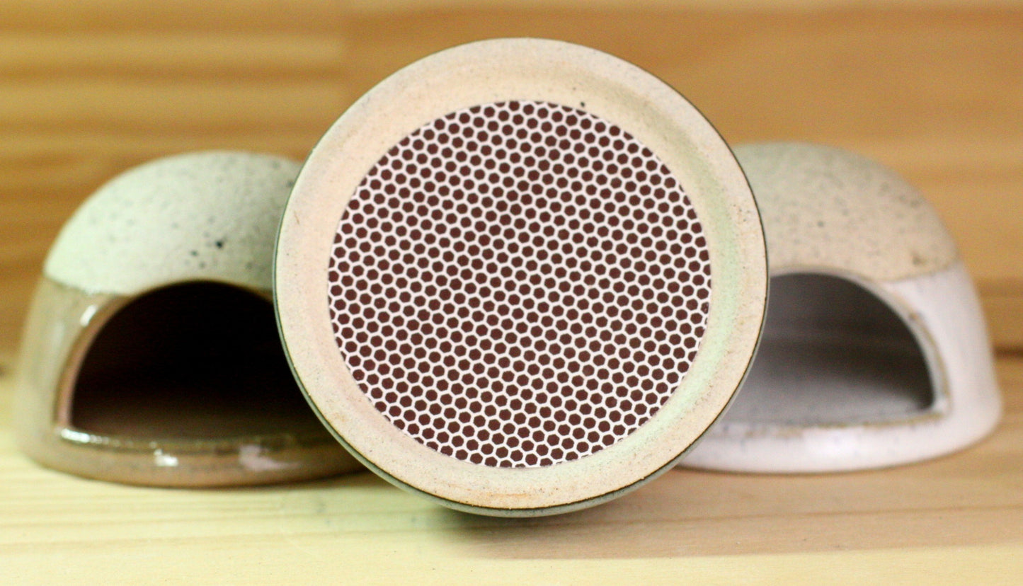 Ceramic match strikers with a textured bottom on a wooden surface