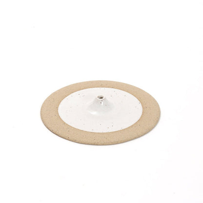 Round incense holder with a white center and beige edge on a white background