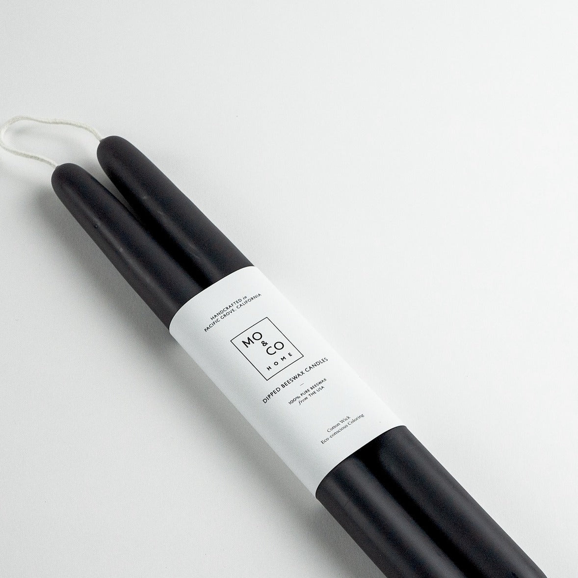 Two black candles on a white background