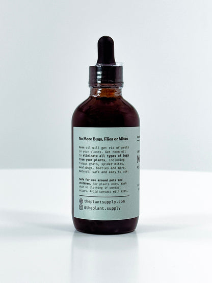 An amber glass dropper bottle with a black rubber dropper cap and a white label, photographed on a clean white background. The label text is partially visible, showing the brand name 'The Plant Supply'.