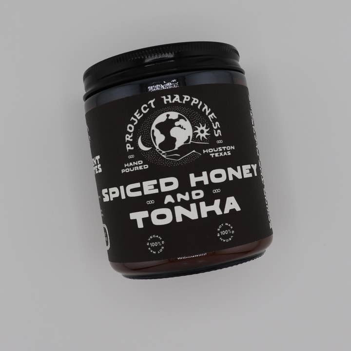 'Spiced Honey and Tonka' candle by Project Happiness on a gray background