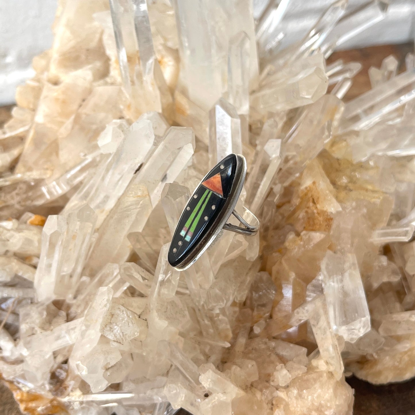 Ring with a colorful stone inlay on a crystal background