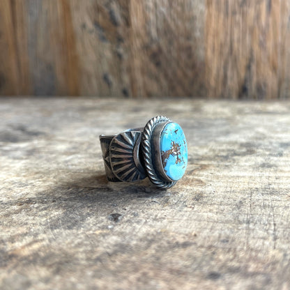 Silver ring with turquoise stone on a wooden surface