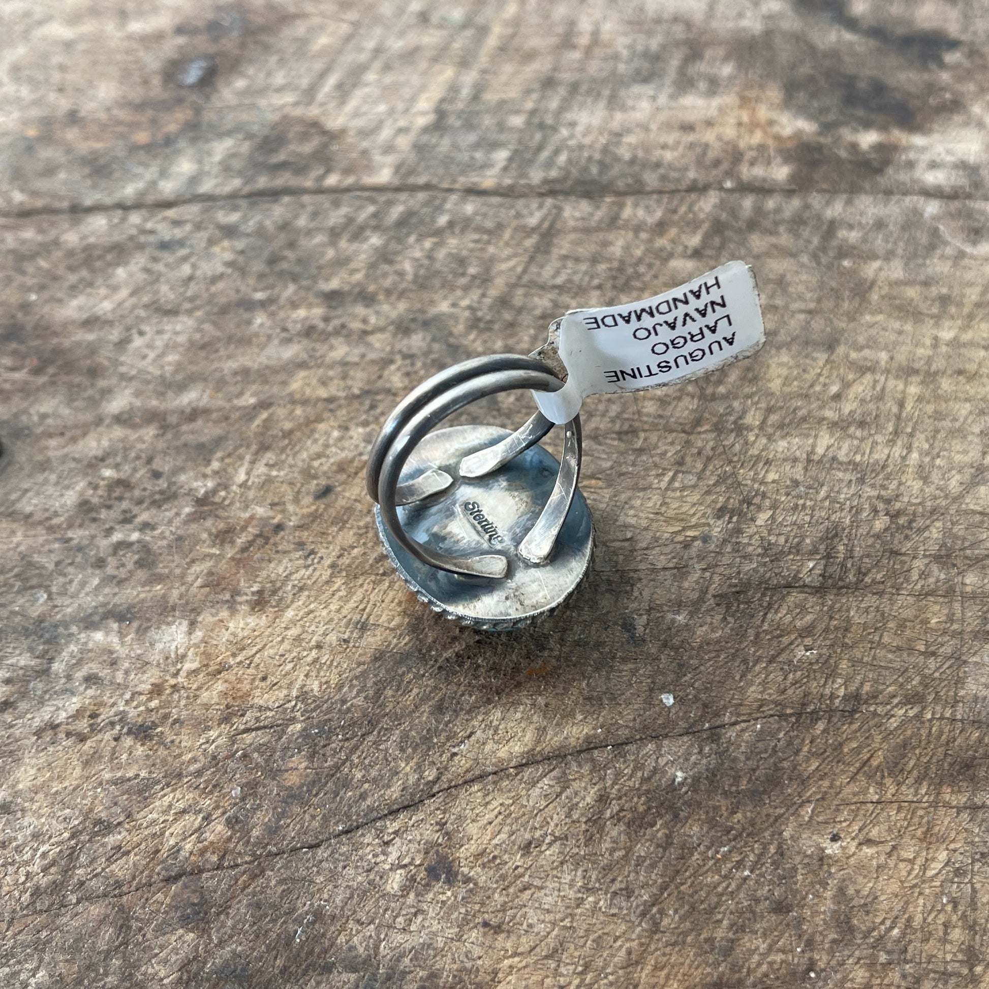Silver ring with a tag on a wooden surface