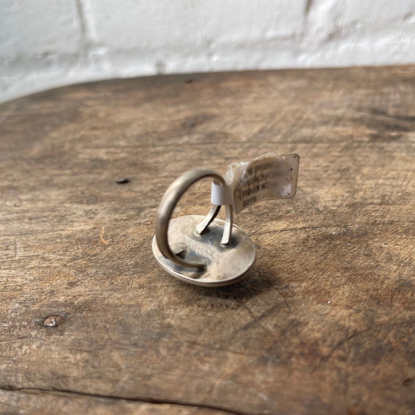 Silver ring with a tag on a wooden surface